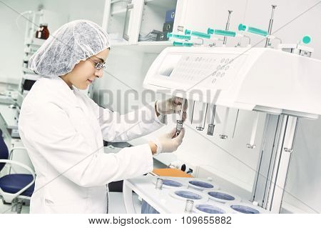 Pharmaceutical scientific  female researcher in protective uniform working with dissolution tester at pharmacy industry manufacture factory laboratory