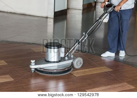 Woman Cleaning The Floor With Polishing Machine