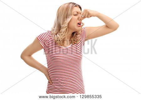 Disgusted woman closing her nose and smelling something bad isolated on white background