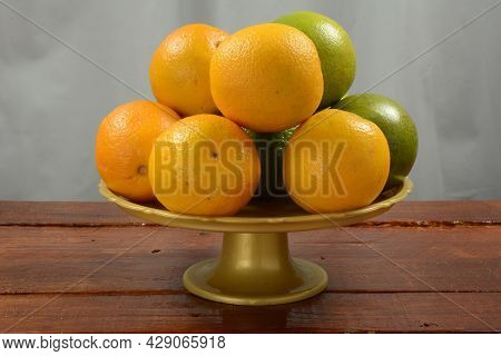 Oranges In A Fruit Bowl On A Wooden Table, Front View