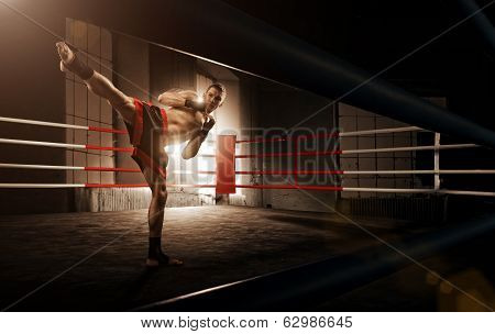 Young man kickboxing in the Arena