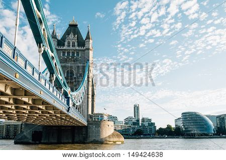 LONDON UK - AUGUST 21 2015: Tower Bridge and City Hall in London UK. The bridge crosses the River Thames close to the Tower of London and has become an iconic symbol of London