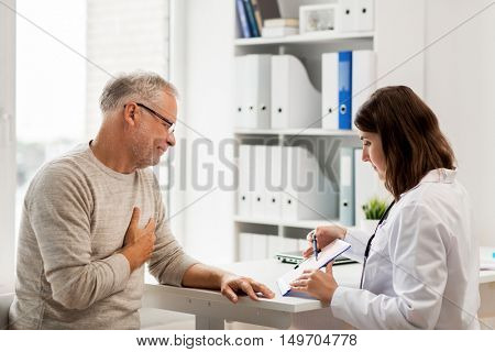 medicine, age, health care, cardiology and people concept - senior man and doctor with cardiogram on clipboard meeting in medical office at hospital