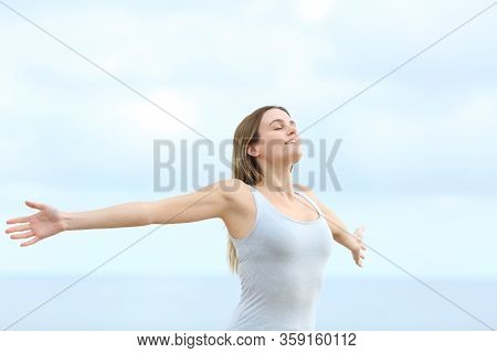 Happy Woman Breathing Deeply Fresh Air Outstretching Arms On The Beach