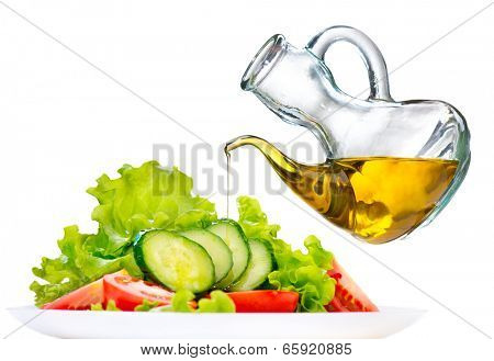 Healthy Vegetable Salad with Olive oil dressing isolated on white background. Pouring Olive oil. Healthy vegetarian food. Vegan. Diet, dieting concept. Lettuce, tomatoes, cucumbers. Organic bio food