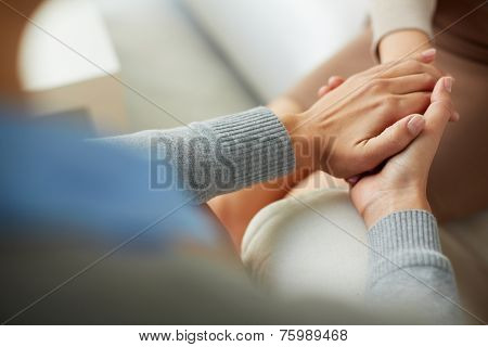 Close-up of psychiatrist hands together holding palm of her patient