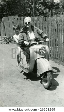 Vintage photo van moeder en dochter op scooter (begin jaren zestig)