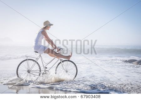 Gorgeous happy blonde on a bike ride at the beach on a sunny day