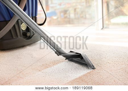 Cleaning service concept. Steam vapor cleaner removing dirt from carpet in flat, closeup