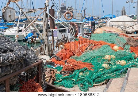 JAFFA - ISRAEL, April 10, 2017: Old Jaffa Port Tel Aviv Israel is now used as a fishing harbour and tourist attraction. Fishnet in front of Ships anchoring at the Jaffa port in a sunny day, Israel