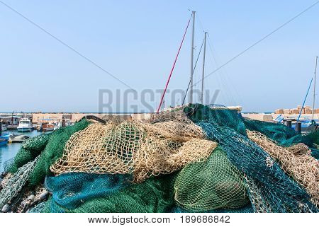 JAFFA - ISRAEL, April 10, 2017: Old Jaffa Port Tel Aviv Israel is now used as a fishing harbour and tourist attraction. Fishnet in front of Ships anchoring at the Jaffa port in a sunny day, Israel