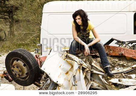 Young woman taking beer in the scrapyard