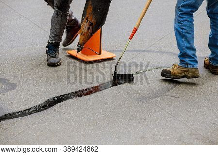 Road Surface Restoration Work In The Worker Performs On Road Patcher Work On The Repair Of Cracks By