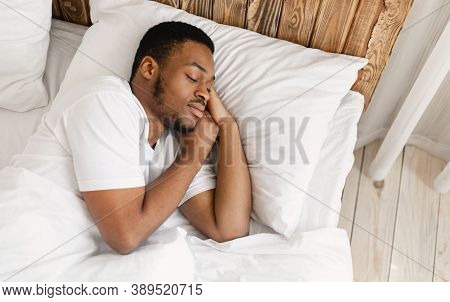 African American Man Sleeping Peacefully Resting With Eyes Closed Lying In Comfortable Bed In Bedroo