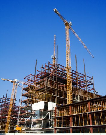 Foto de Construcción con grandes grúas amarillas y cielo azul - Imagen libre de derechos