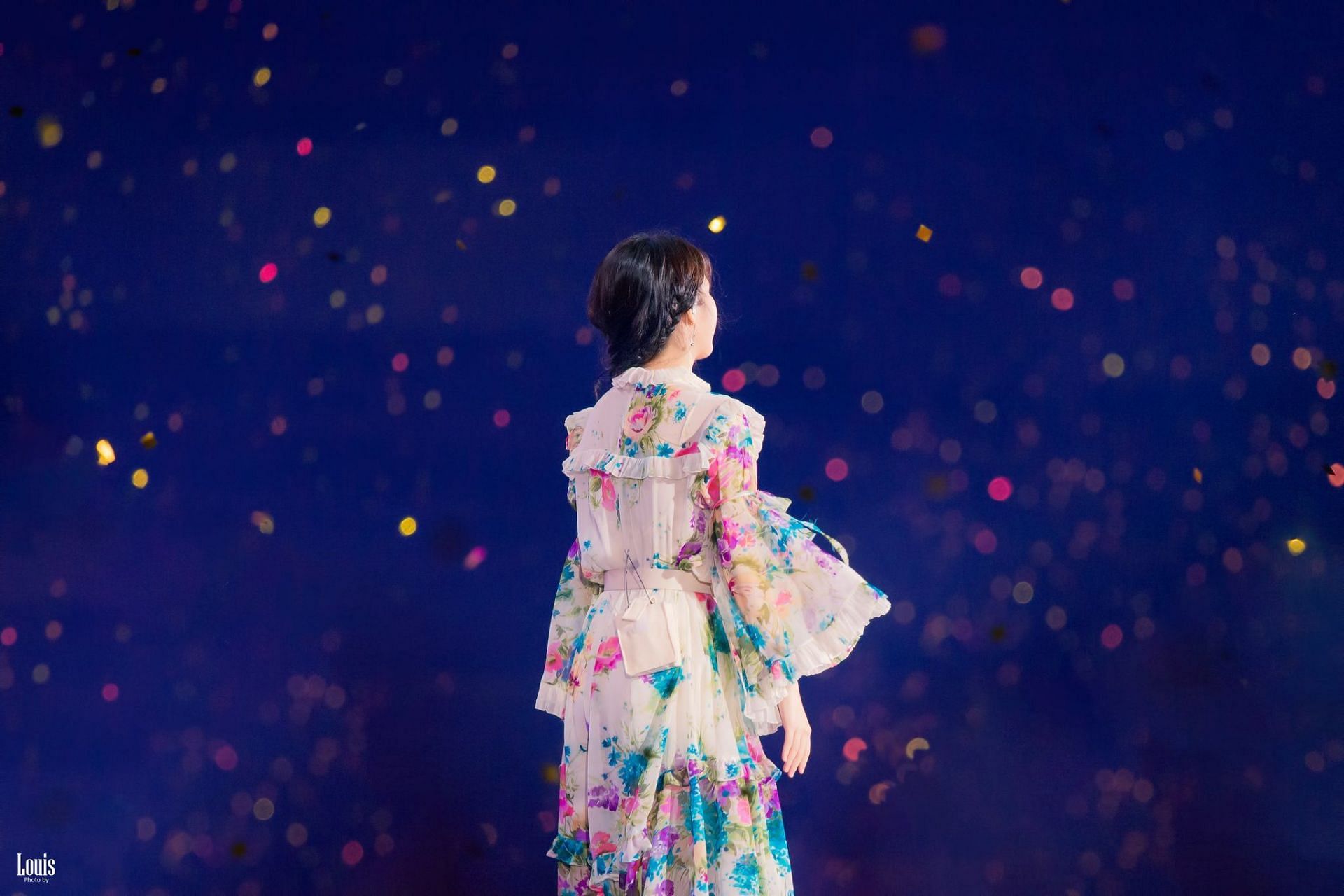 Jieun looking at UAENAs in the audience for her Golden Hour concert in a beautiful multi-colored floral dress (Image via Twitter/IU_Louis)