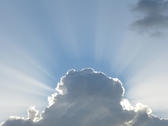 beams of light emerging from behind a cloud after a passing storm