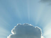 a storm cloud with glowing rim light and beams of sunlight emerging from the edges