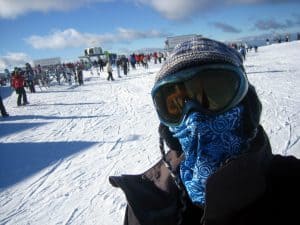 A man wearing a High Uv Buff® as face mask in the snow. He is in a ski resort. © unknown