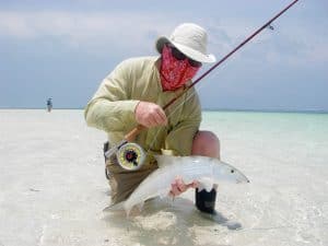 Fly fisher holding a catch in the flats. He is wearing a High Uv Buff® as face mask. The cooling effect makes the face mask comfortable. © Pat Ford http://www.patfordphotos.com/. Licenced by Original Buff S.A for the promotion of the High Uv Buff®