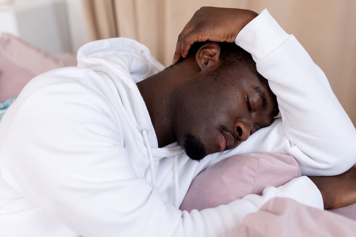 Man resting his head on his shoulders with his eyes closed