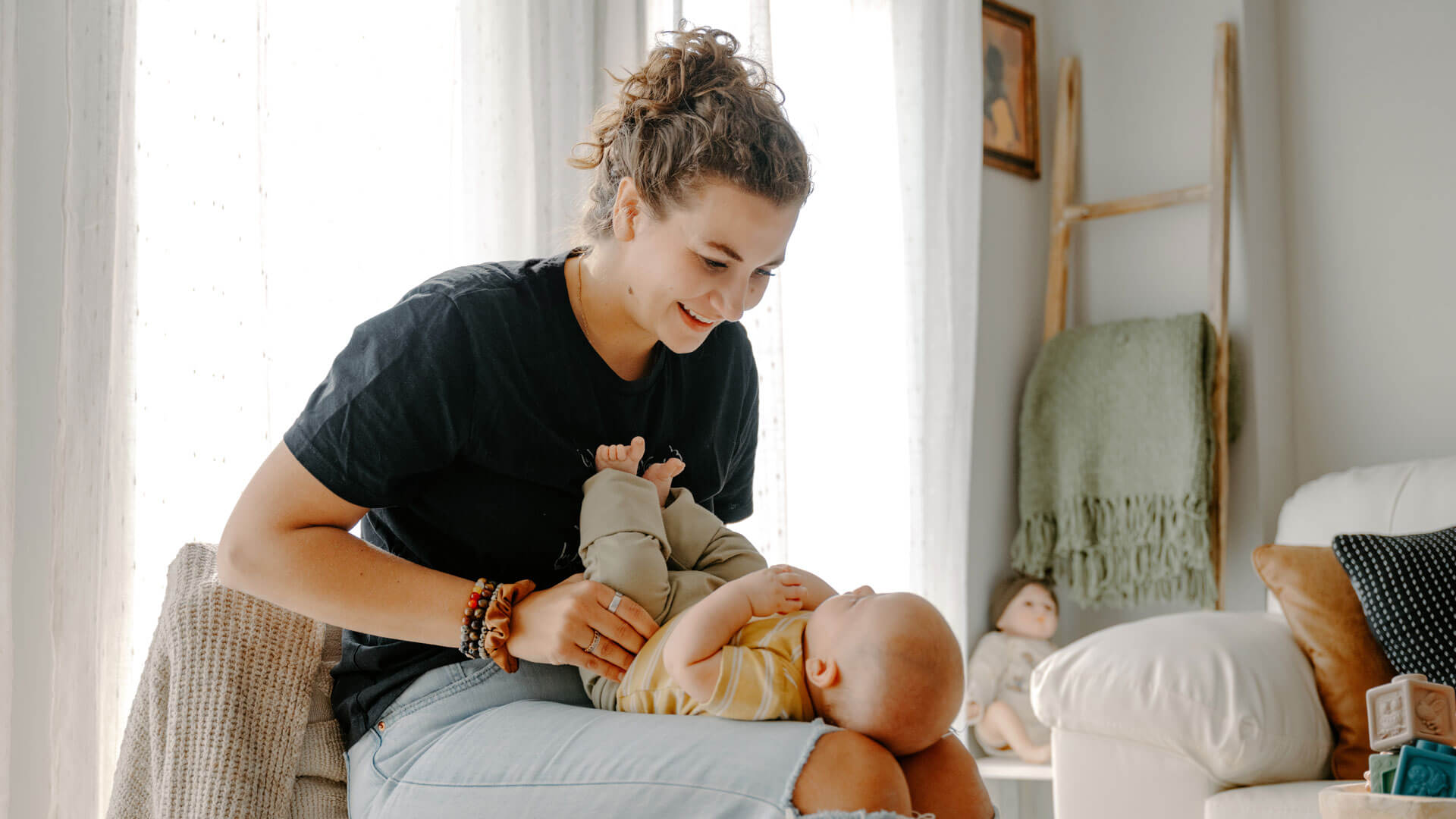 Sienna is in her light-filled office, seated and holding a baby on her lap.