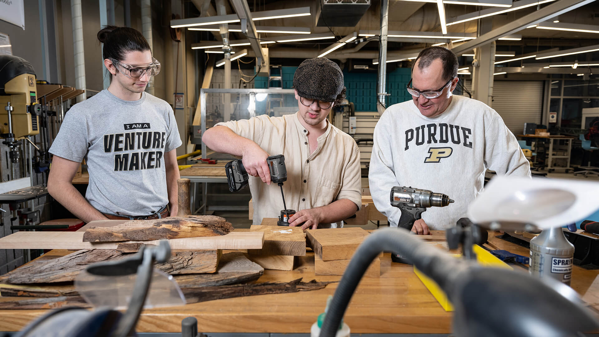 Purdue student Lief Wezeman, center, makes a set of bowls at the Bechtel Innovation Design Center as Silas Owen and Dan Bollock look on.