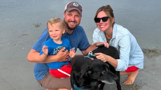 Toren Peterson on a beach with his wife, son, and dog.