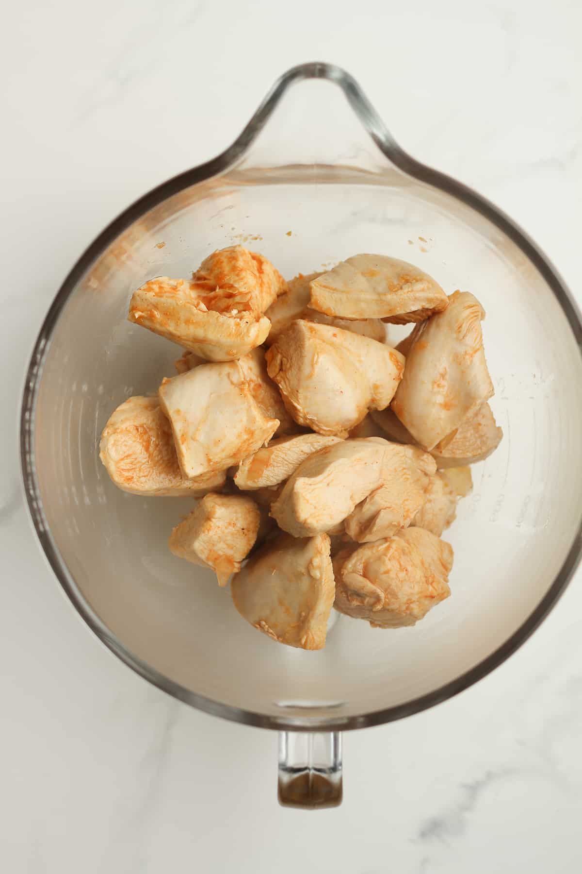 A mixing bowl with the chicken pieces inside.