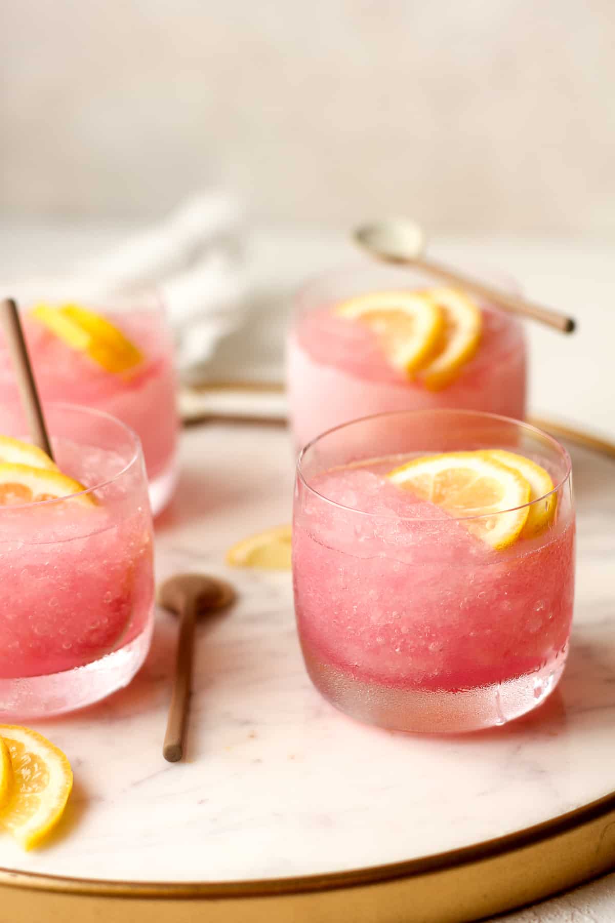 Side view of a tray of pink vodka slushies.