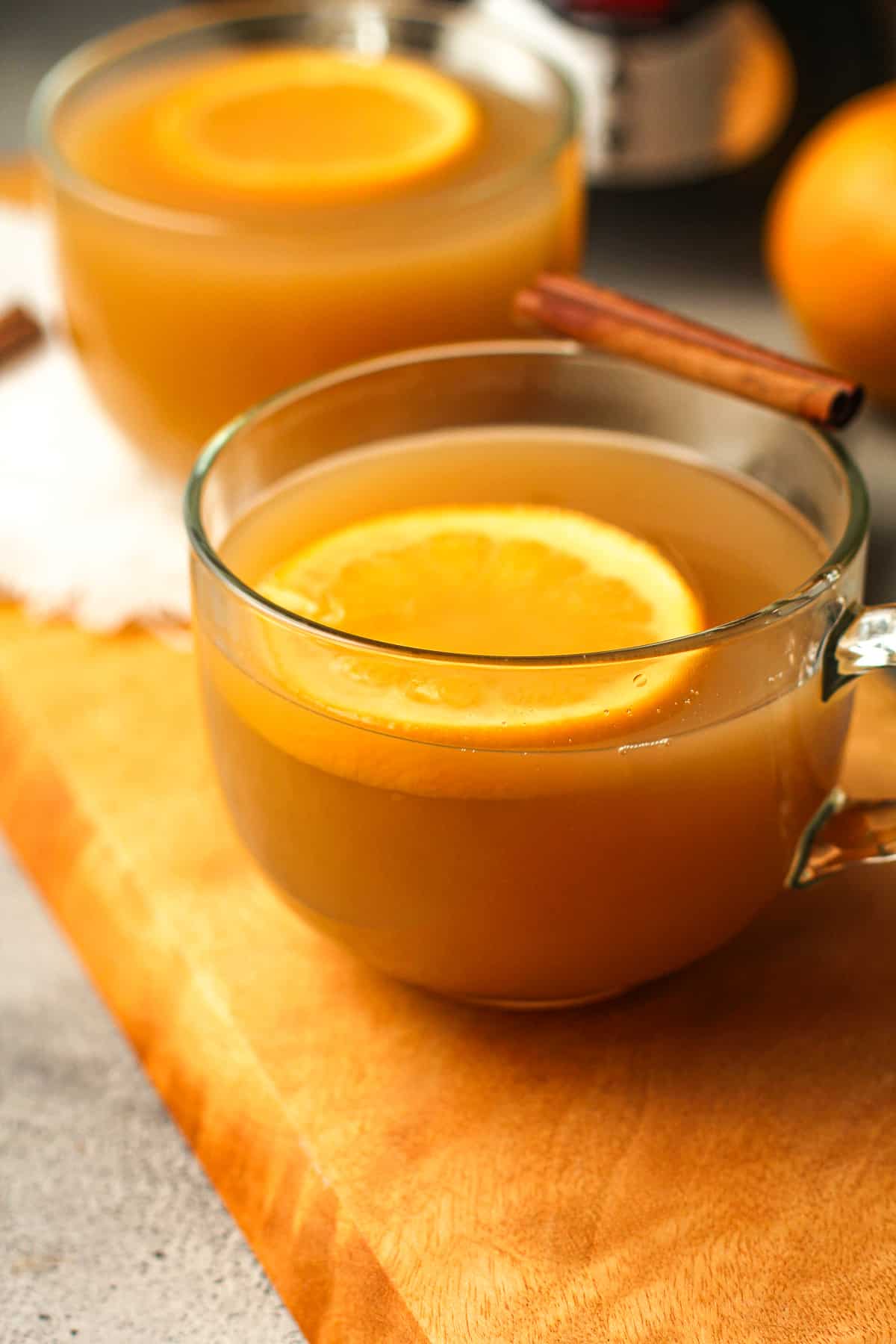 Side view of two glass mugs of mulled cider.