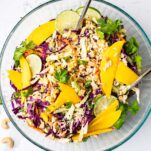 A large glass bowl filled with a colorful asian style cabbage salad.