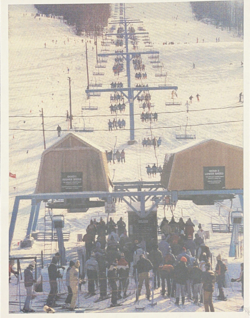 photo of ski lifts in winter with skiers waiting to load