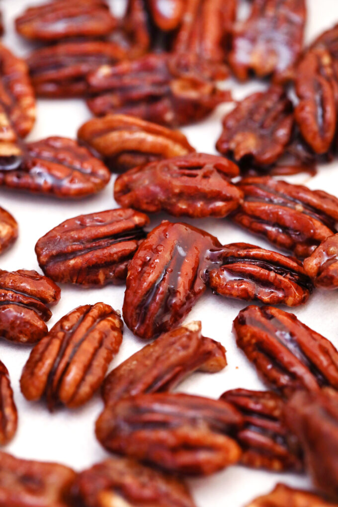 glazed pecans spread in a layer on parchment paper