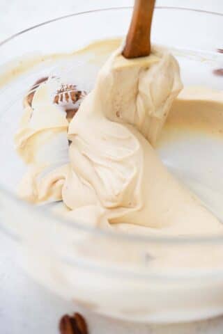 stirring a creamy pecan cream pie filling in a bowl