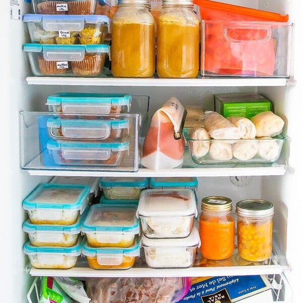 An open freezer filled with food prep containers and meals