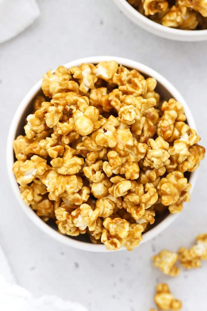 overhead view of two white bowls of crispy homemade caramel corn