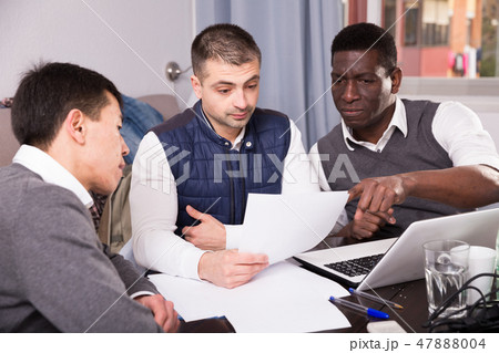 Three seriouse men are working with project and talking about documents together 47888004