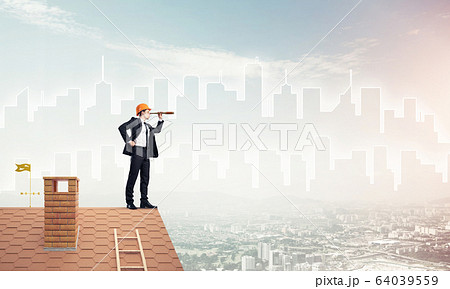 Engineer man standing on roof and looking in spyglass. Mixed med 64039559