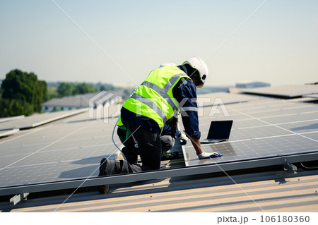 Engineers with safety helmet checking solar system at solar power farm 106180360