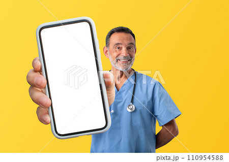 Mature medical worker man in uniform demonstrating smartphone screen, studio 110954588