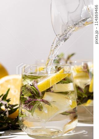 Lemon water with mint pouring into glass. 114869466