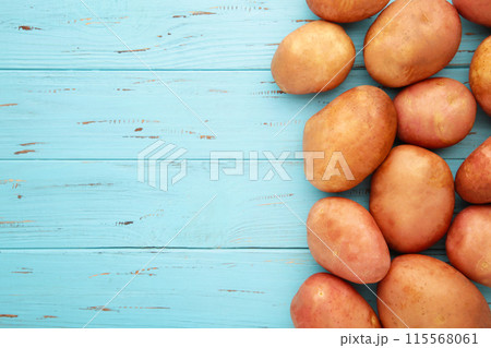 Potatoes on blue wooden background, top view 115568061