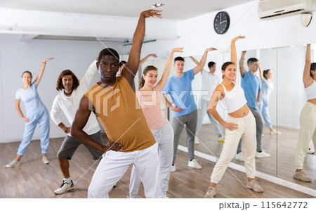 Group of different people rehearsing dance in dance studio 115642772