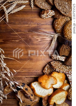 Assortment of baked bread on wooden table background 118755525