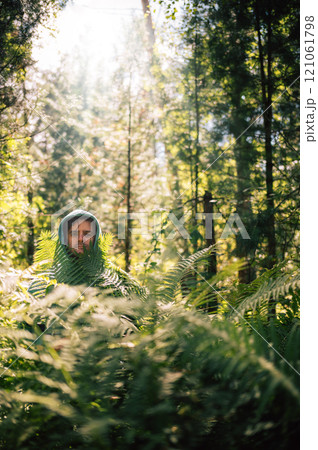 Person Hidden Among Lush Forest Ferns 121061798