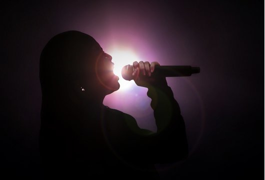 Women singing under bright spotlight