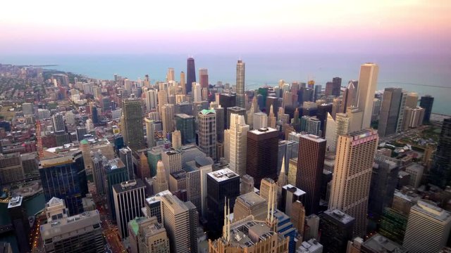 Aerial view of downtown Chicago city skyline and Lake Michigan at sunset in Chicago, Illinois (logos blurred for commercial use)