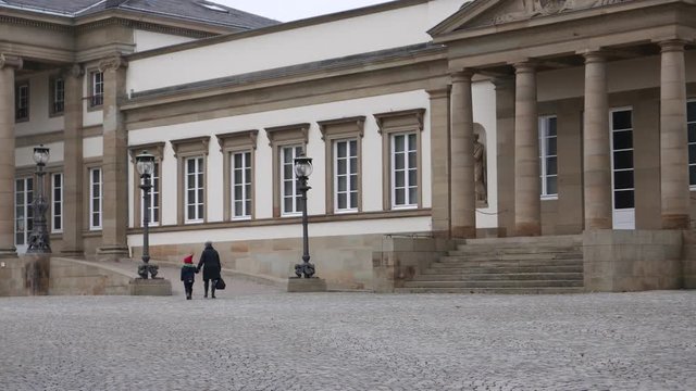 A woman and child entering a museum, with camara pan to the right.  State Museum of Natural History Stuttgart in Rosenstein Palace.