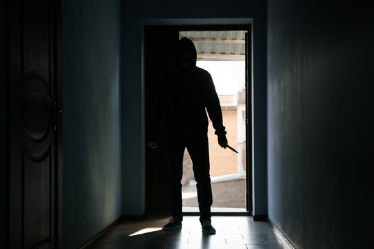 Man with knife in dark room. Dangerous criminal